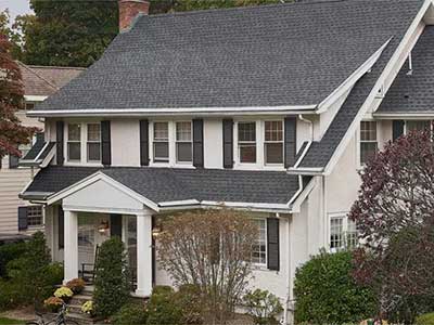 Front view of a typical mid-class home with gray GAF shingles on its roof