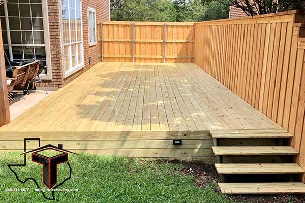 Medium sized deck with no staining, perfectly installed by Trutex between the side of a patio area and a fence