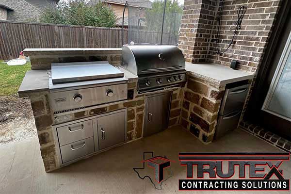 Close up of a grilling counter area made of bricks in an outdoor kitchen area installed by Trutex